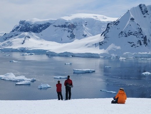 Reisende vor schneebedeckten Bergen und Eisschollen Antarktis