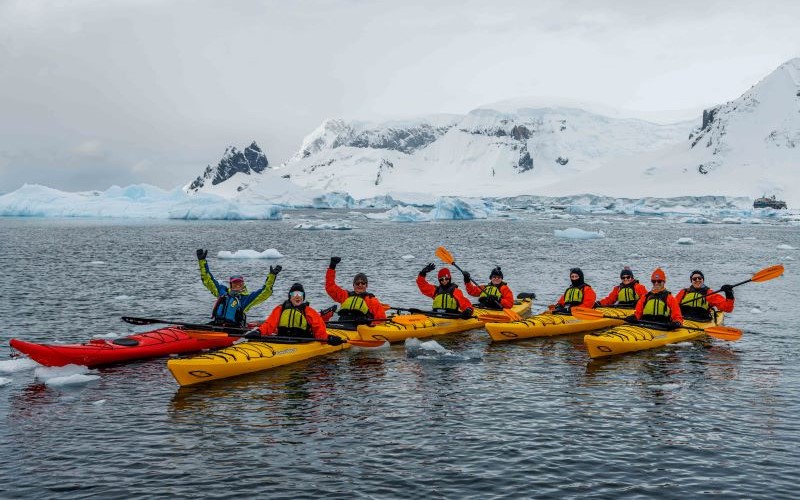 Eine Gruppe von Kajakern in antarktischen Gewässern während der Antarktis Kreuzfahrt.