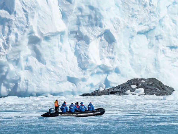 Auf der Antarktis Expedition fährt das Zodiac an einem riesigen Eisberg vorbei.