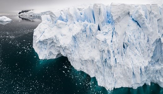 Eisberge der Antarktis ragen gewaltig aus dem dunklen, klaren Wasser.