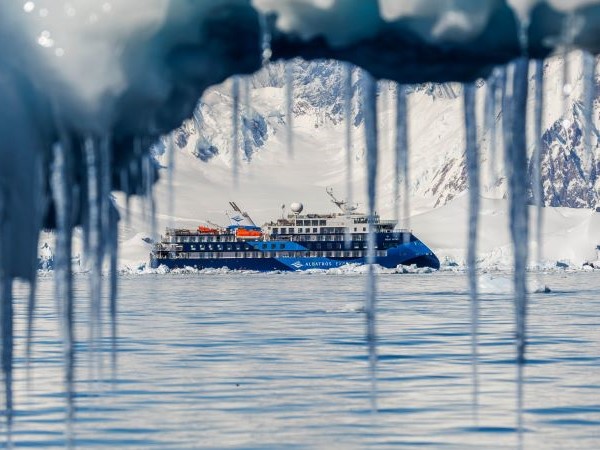 Durch Eiszapfen schaut der Fotograf auf das Schiff der Albatros Expeditions in Foyn Harbour.