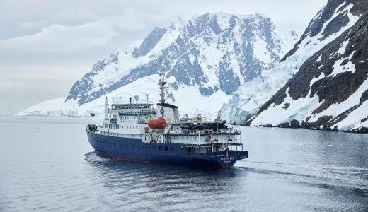 Schiff Plancius vor schneebedeckten Bergen Antarktis